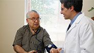 Doctor checking mans blood pressure